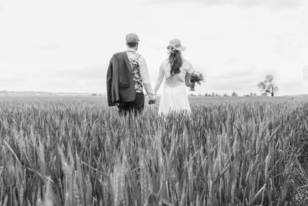 mariés de dos dans un champ de blé en Auvergne